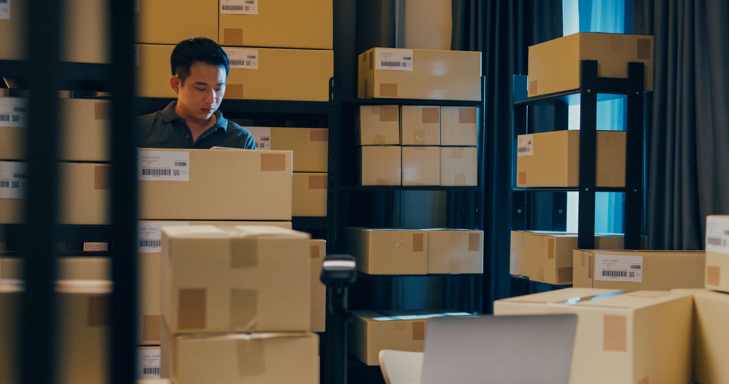 man surrounded by shipping boxes
